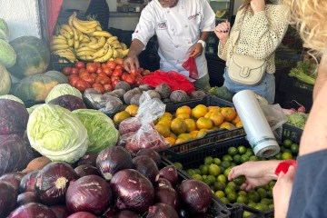 a group of people at a fruit stand