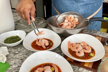 a person holding a plate of food on a table